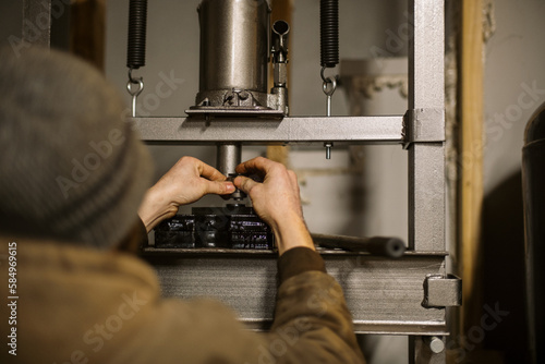Mechanic worker installing bearings with a hydraulic press 