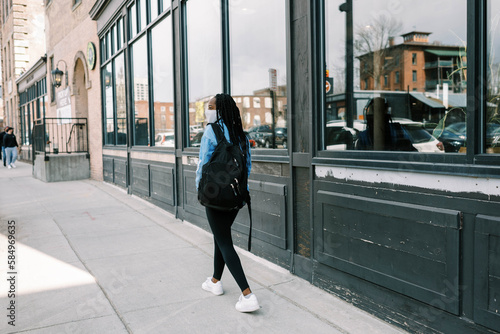 young black woman with mask walking in a city photo