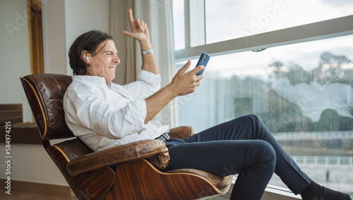 Businessman with smartphone listening to favorite music photo