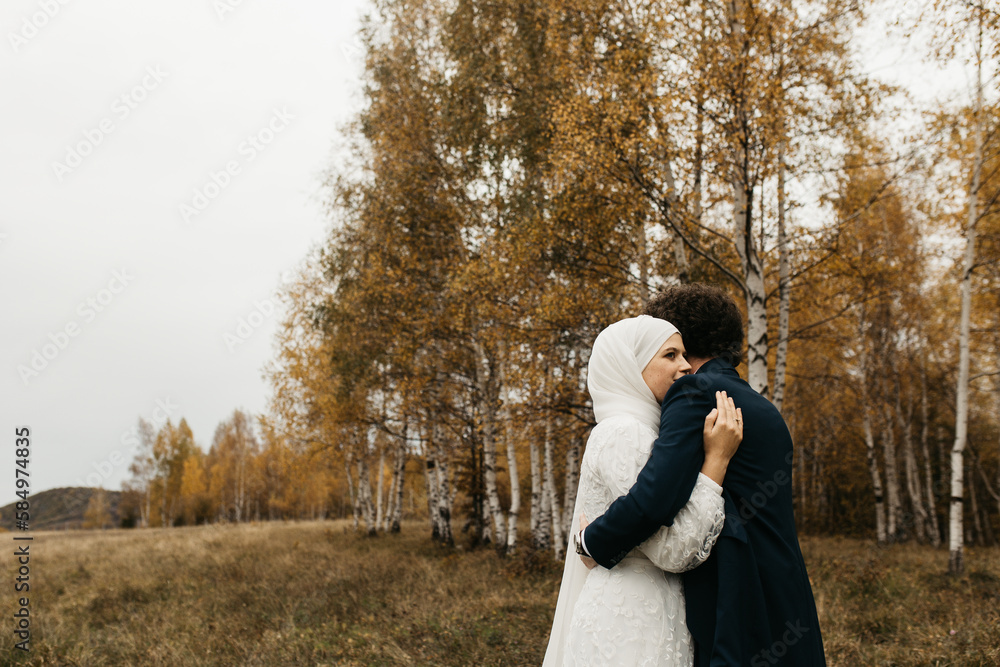 Happy couple standing and hugging in the autumn filed Happy couple standing and hugging in the autumn filed