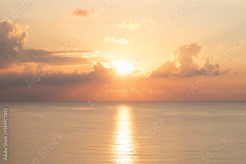 pastel orange and yellow sea water surface and sky at sunset photo