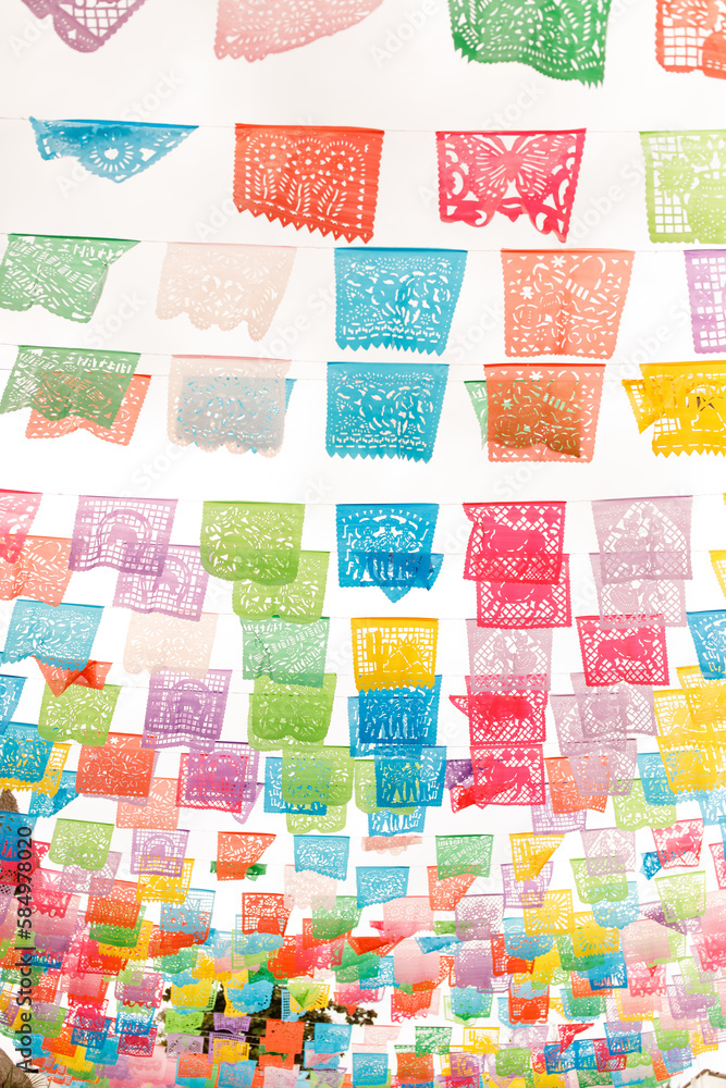 Colorful papel picado hangs above the street Colorful papel picado hangs above the street