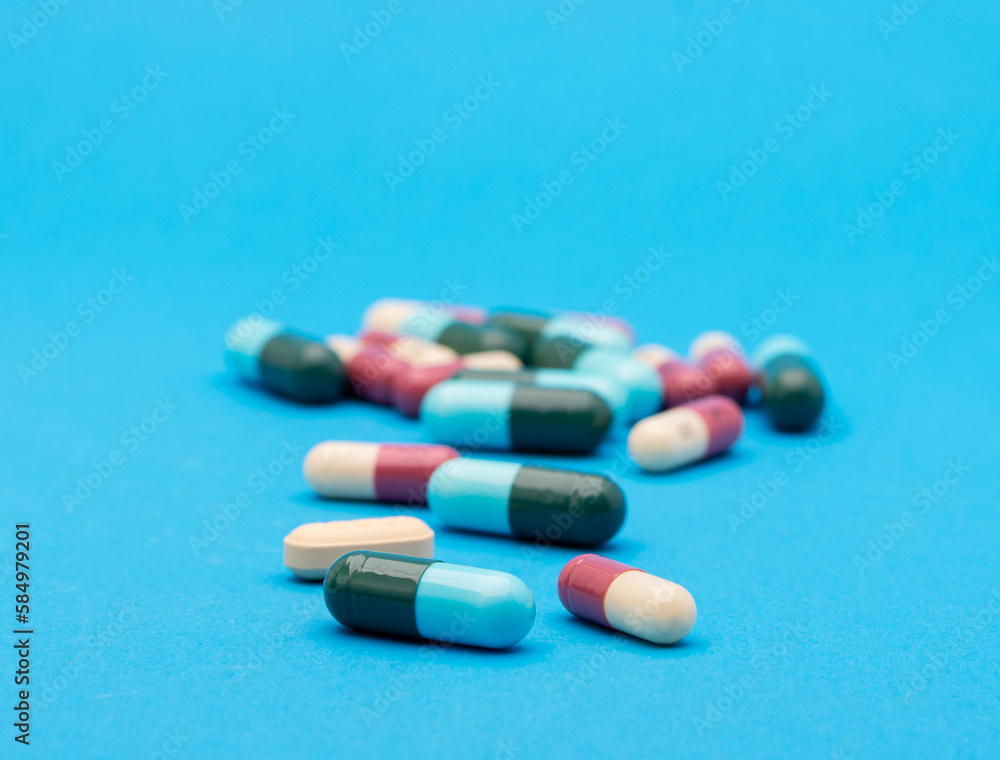 green capsule pill on blue background table medicine vitamin antibiotic and medical treatment of hospital and clinic
