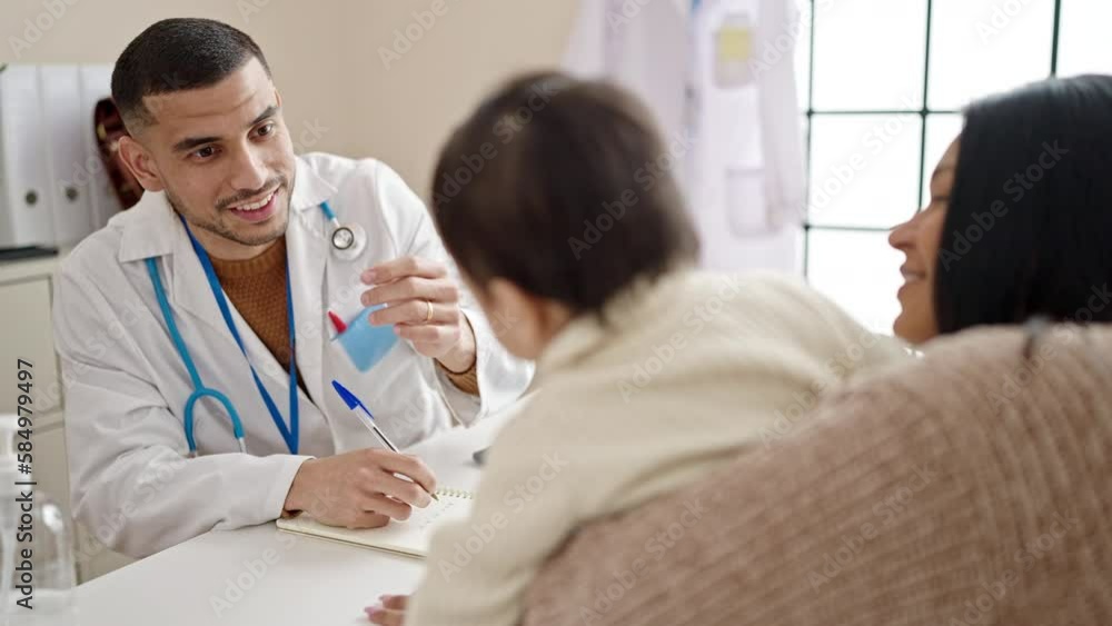 Couple and son having medical consultation writing on notebook at clinic