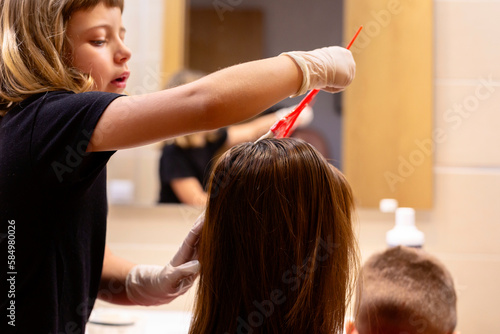 Girl dyeing her mother's hair photo