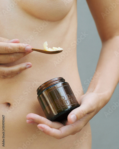 Naked young woman posing with natural body butter photo