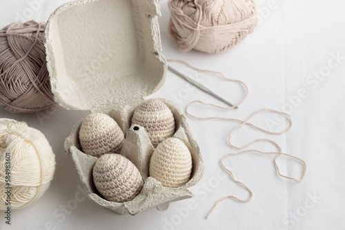 Set of cute easter crocheted eggs, pastel color in the eggbox