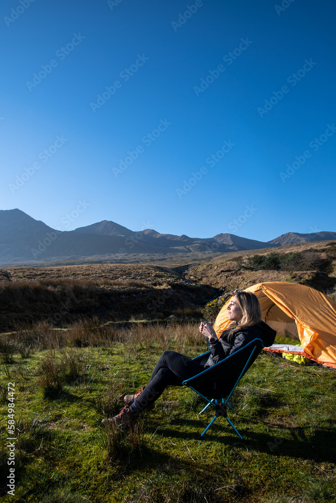 Fototapeta premium female traveler camper enjoying the sun and a coffee