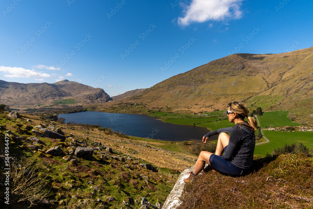 Sitting cyclist woman looking at the mountainous landscape