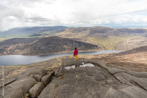 Woman standing on top of the Slieve Binnian Mountains photo