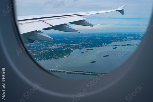 View from porthole. Aircraft window or porthole. Aircraft wing seen through porthole. Plane porthole
