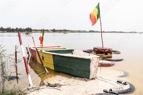 boat on pink lake in senegal with senegal flag photo