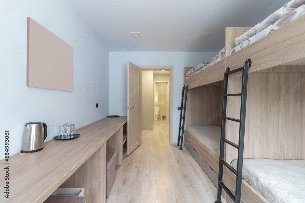 Hostel dormitory beds arranged in dorm room with white plain bunk bed ...