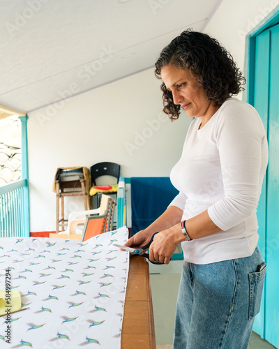 Dressmaker cutting a canvas with scissors photo