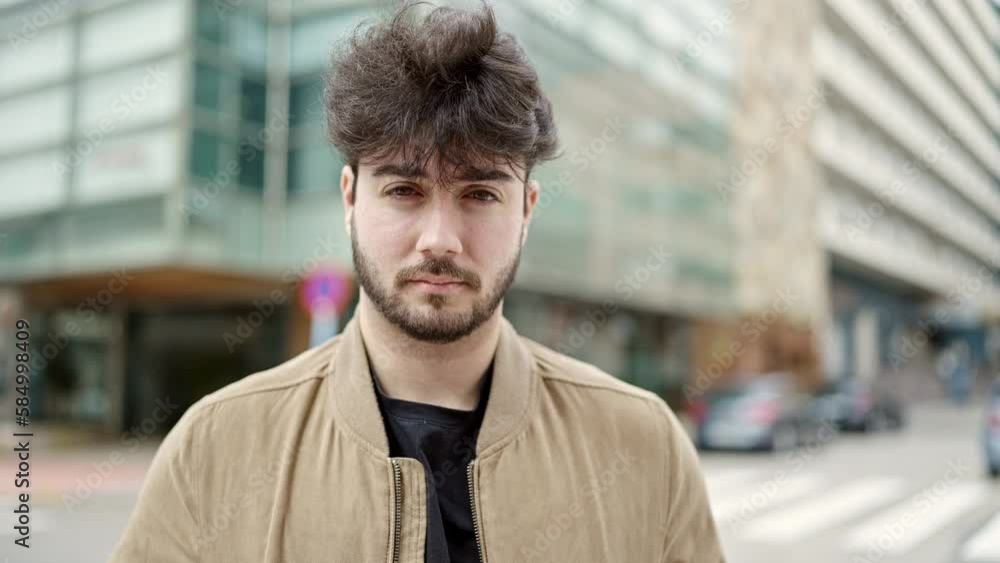 Young hispanic man standing with sadness expression at street Young hispanic man standing with sadness expression at street