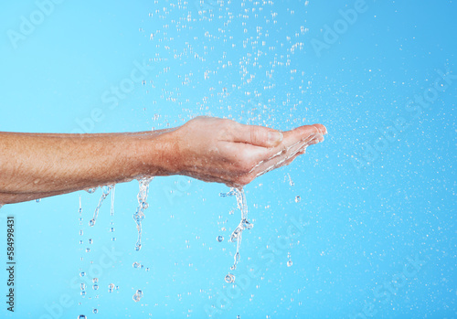 Woman hands, cleaning and water in a studio for skincare, safety and healthcare from virus. Isolated, blue background and hand wash for hygiene wellness and sanitary protection with liquid stream
