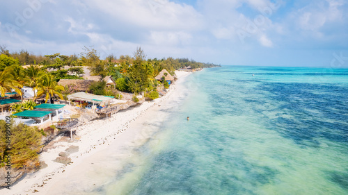 Fototapeta Naklejka Na Ścianę i Meble -  Experience the tranquility and beauty of Zanzibar Beach, where crystal-clear waters meet white sandy shores and the sounds of palm trees rustling in the breeze offer a calming escape.