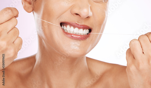 Face  smile and woman flossing teeth for cleaning  hygiene or tooth care in studio isolated on a purple background. Oral health  cosmetics and happy mature female model with dental floss for wellness