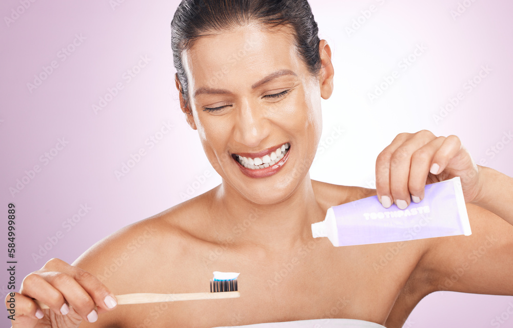 Smile, woman and bamboo toothbrush and toothpaste in studio isolated on a purple background. Eco friendly, cleaning and happy mature female brushing teeth with natural wooden brush for dental hygiene Smile, woman and bamboo toothbrush and toothpaste in studio isolated on a purple background. Eco friendly, cleaning and happy mature female brushing teeth with natural wooden brush for dental hygiene