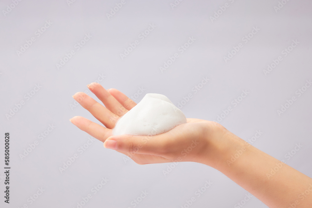 A beautiful female hand with white cleanser foam texture displayed on. Skin care and cleansing, natural beauty and cosmetology concept - obrazy, fototapety, plakaty 