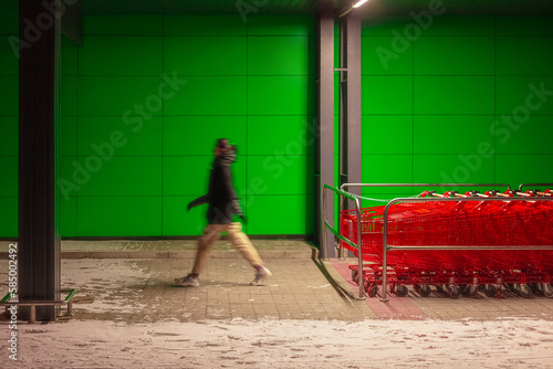 A lot of shopping carts on the background of a walking man photo