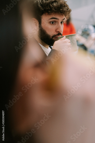 A close up photo of handsome male business person taking a sip of super hot coffee