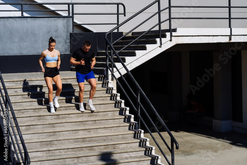 Sporty couple running on a stairs in the city