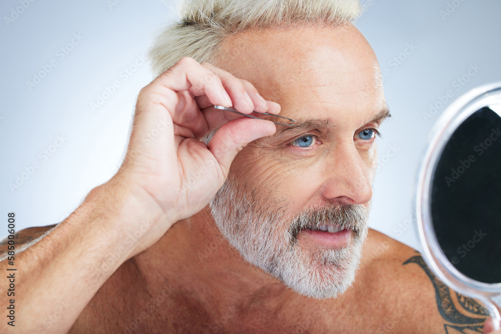 Senior man, bathroom tweezers and mirror check in a studio doing hair removal and grooming. Wellness, eyebrows and beauty routine of a male model care with grey background and steel tools for face Senior man, bathroom tweezers and mirror check in a studio doing hair removal and grooming. Wellness, eyebrows and beauty routine of a male model care with grey background and steel tools for face