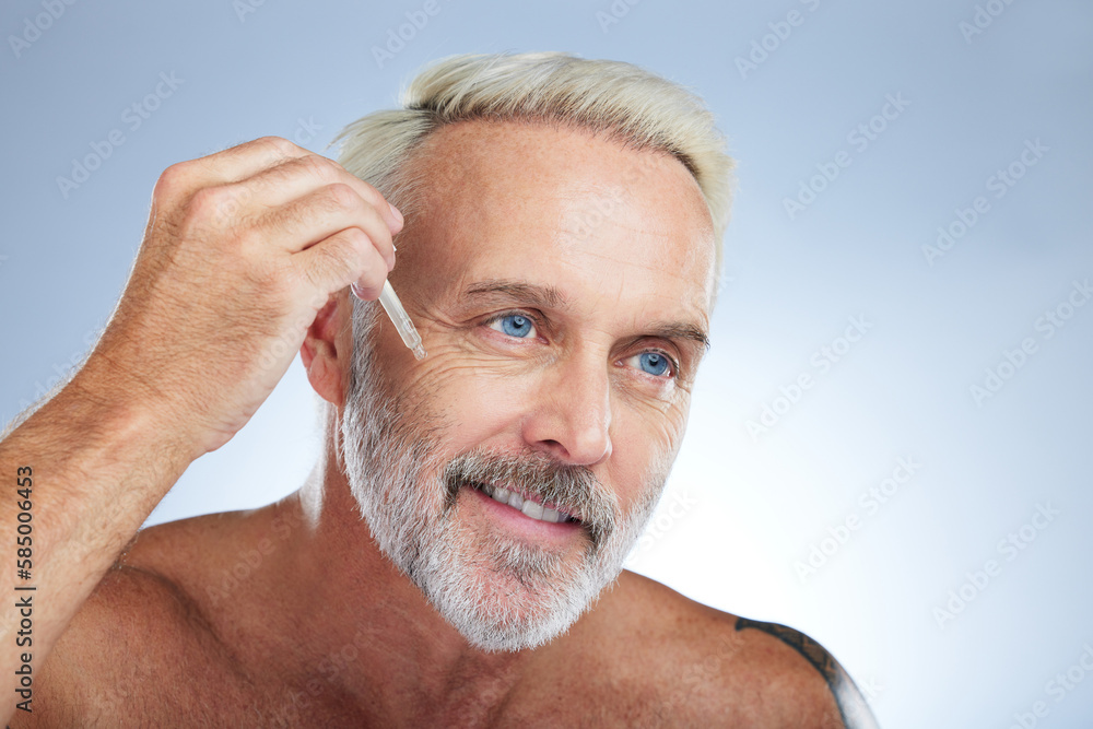 Obraz premium Old man, smile and facial oil for skincare, beauty and grooming, apply serum on face against studio background. Dropper, anti aging cosmetic care with senior male and mockup, hygiene with dermatology