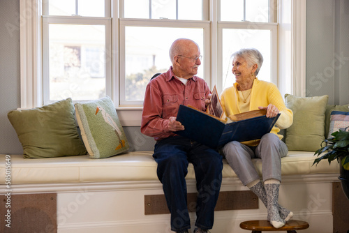 Senior Citizen couple at home Looking at family photo album  photo