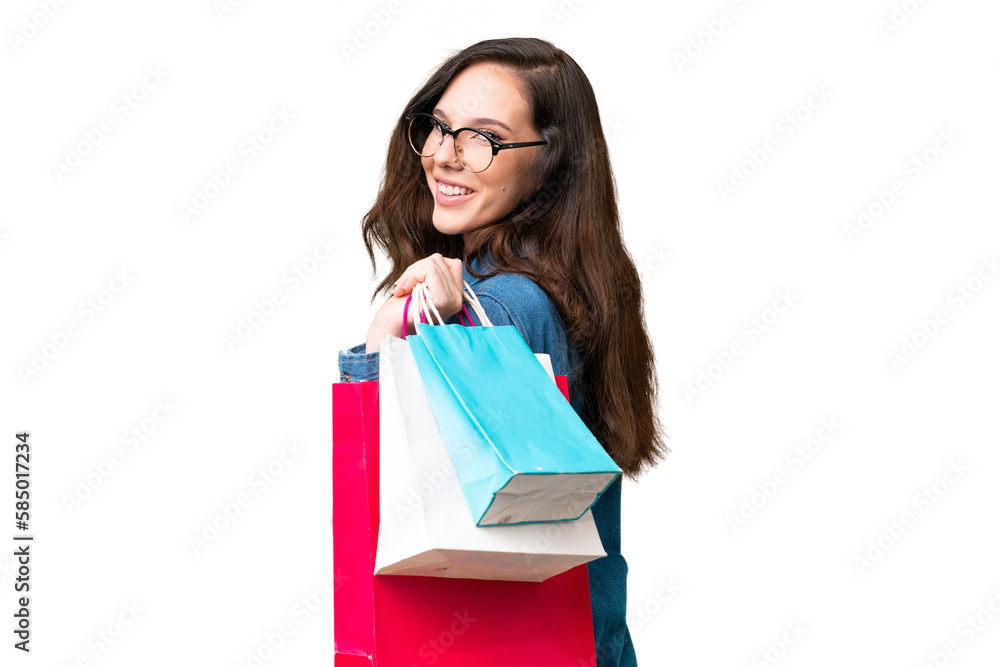 Young caucasian woman over isolated background holding shopping bags and smiling Young caucasian woman over isolated background holding shopping bags and smiling