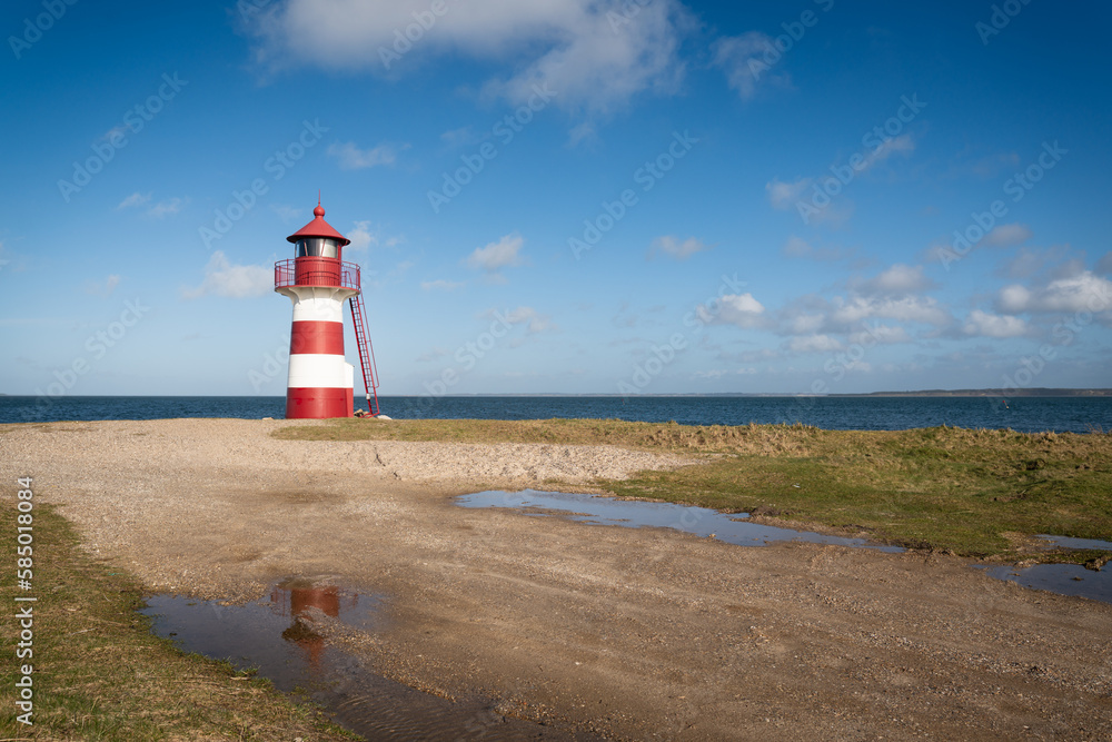 red striped lighthouse on the sandy coast of a fjord in denmark red striped lighthouse on the sandy coast of a fjord in denmark