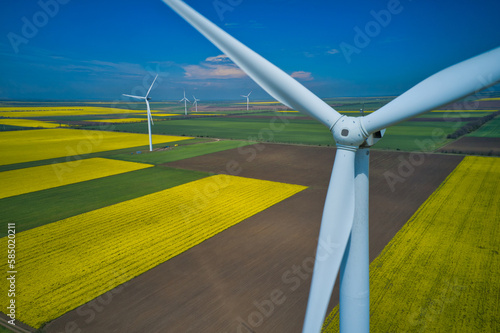 Aerial drone view of wind mills rotating by the force of the wind and generating renewable energy. Renewable alternative energy sources.