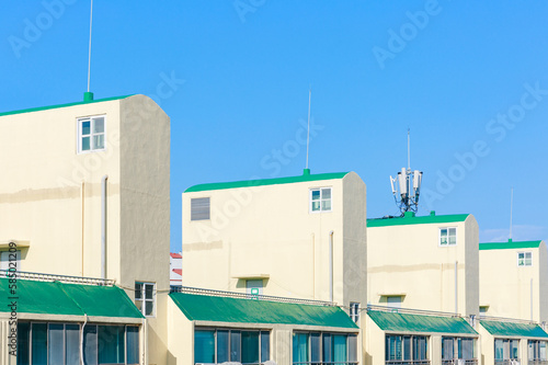 Green and yellow apartment building rooftop structure. photo