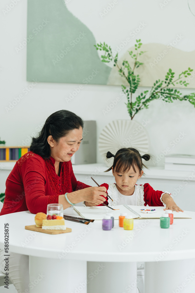 © Marc Tran/Stocksy - happy older grandmother drawing and painting.