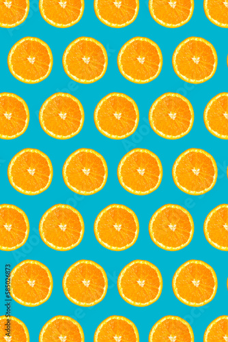 Uniform pattern of half slices of orange fruit on a light blue background. Colorful pattern of orange candies for design backgrounds