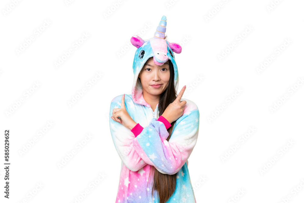 Young Asian woman with unicorn pajamas over isolated chroma key background pointing to the laterals having doubts Young Asian woman with unicorn pajamas over isolated chroma key background pointing to the laterals having doubts