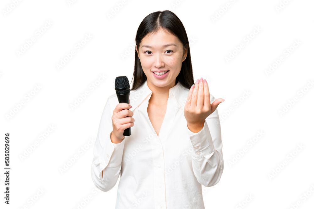 Singer picking up a microphone over isolated chroma key background inviting to come with hand. Happy that you came Singer picking up a microphone over isolated chroma key background inviting to come with hand. Happy that you came