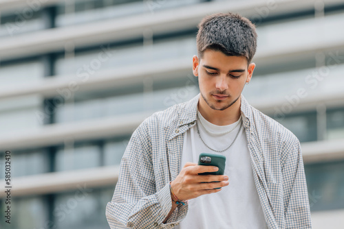 young man on the street looking at the mobile phone or smartphone