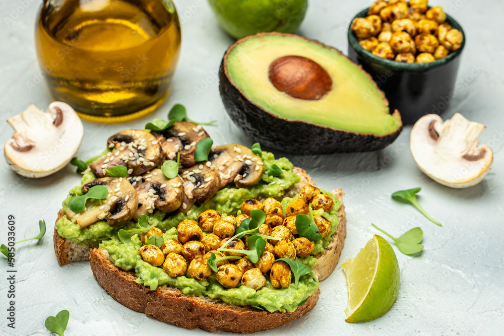 Healthy avocado toasts with chickpeas and mushrooms on a wooden background, vegetarian vegan food. top view. place for text Healthy avocado toasts with chickpeas and mushrooms on a wooden background, vegetarian vegan food. top view. place for text