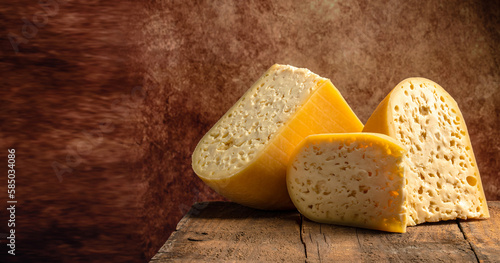 close up french hard cheese with holes emmentaler on a wooden background. farmer market. top view. place for text