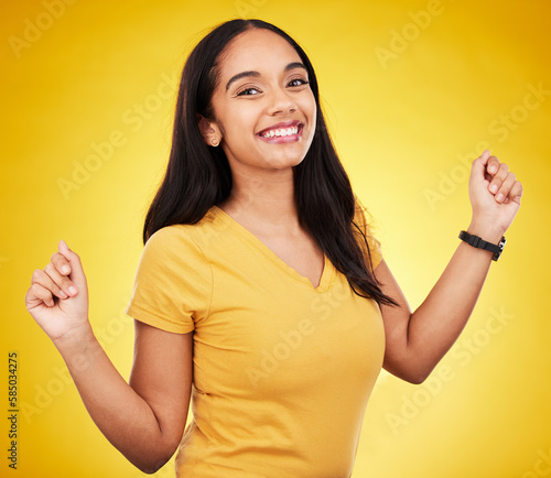 Happy, young and portrait of a beautiful woman isolated on a yellow background in a studio. Casual, smile and a gorgeous girl looking cheerful, cute and fashionable in a bright shirt on a backdrop