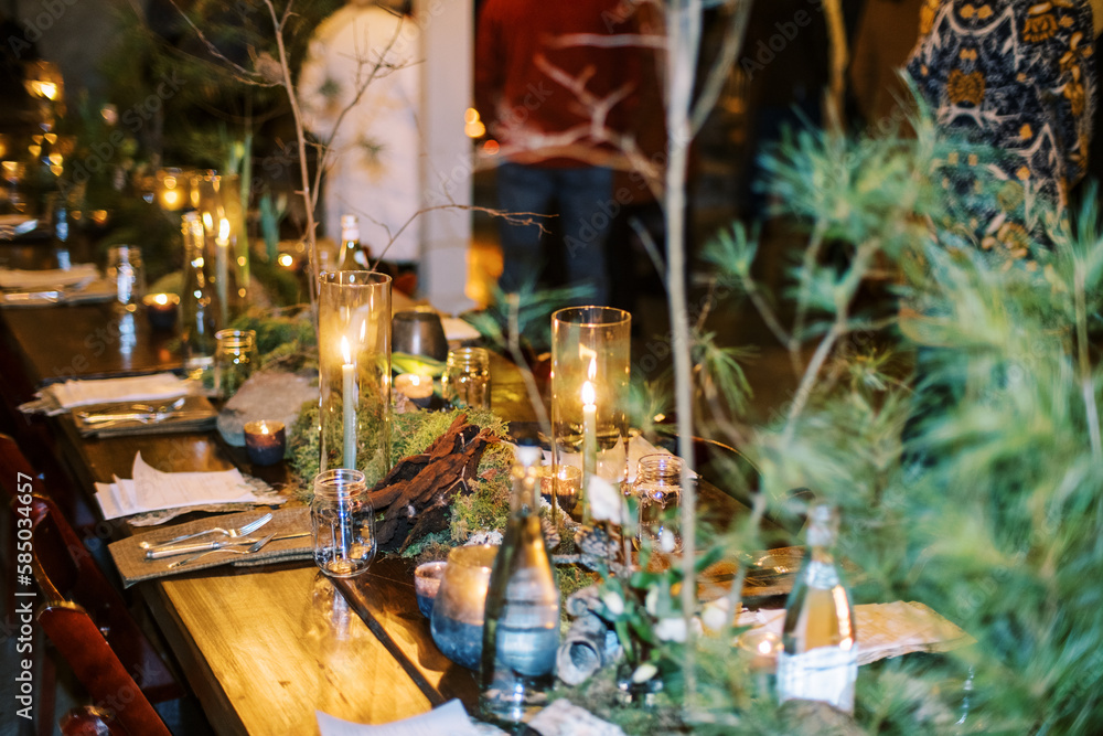 Decorated table with floral arrangements at an indoor dinner party Decorated table with floral arrangements at an indoor dinner party
