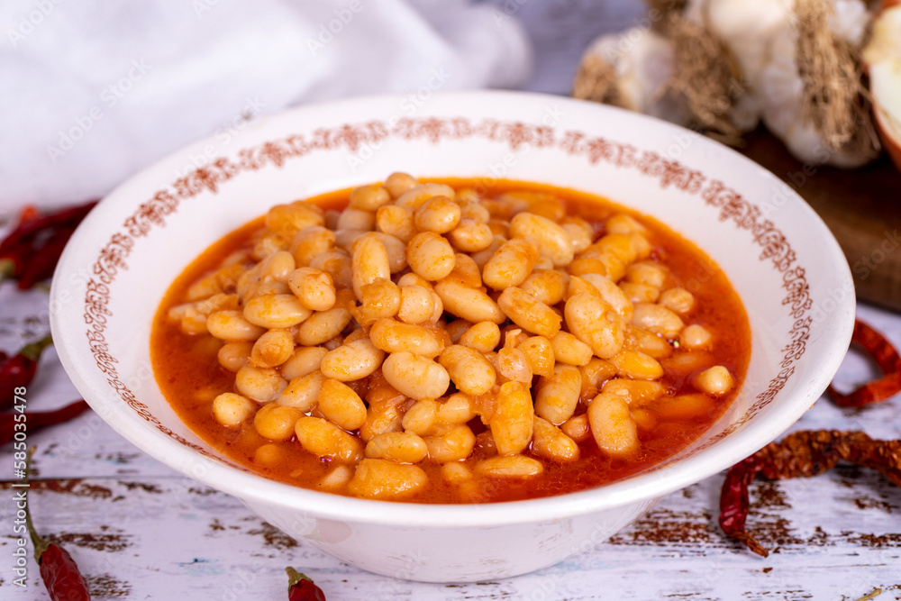 Dry bean meal. Dry bean dish in plate on white wooden background. Local name kuru fasulye. Close up Dry bean meal. Dry bean dish in plate on white wooden background. Local name kuru fasulye. Close up