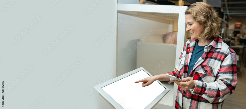 Woman uses the self-service kiosk in the store. Woman uses the self-service kiosk in the store.