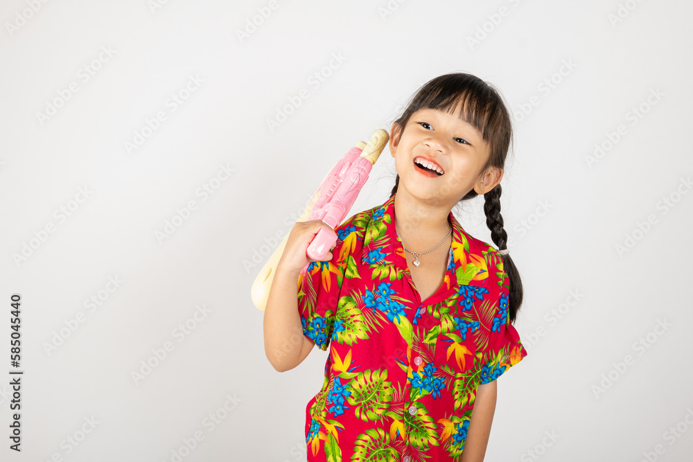 Happy Songkran Day, Asian kid girl with floral shirt hold water gun, Thai child funny hold toy water pistol and smile, isolated on white background, Thailand Songkran festival national culture concept Happy Songkran Day, Asian kid girl with floral shirt hold water gun, Thai child funny hold toy water pistol and smile, isolated on white background, Thailand Songkran festival national culture concept
