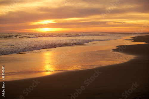 beautiful orange sunset on the beach with cloudy sky