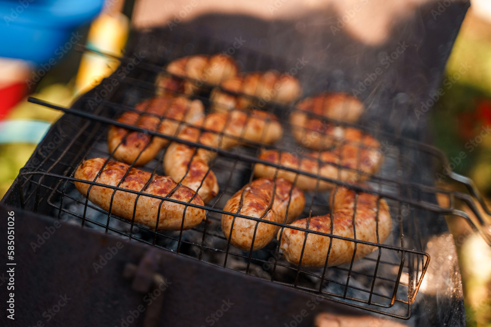 Sausages are grilled on a grill, frying in the fresh air. Street food.