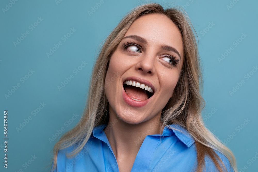 photo of an adorable young woman with a wide smile on a blue background photo of an adorable young woman with a wide smile on a blue background