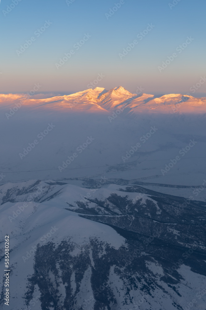 Aerial high altitude view of Mount Aragats highest mountain in Armenia lit by rising sun, Caucasus